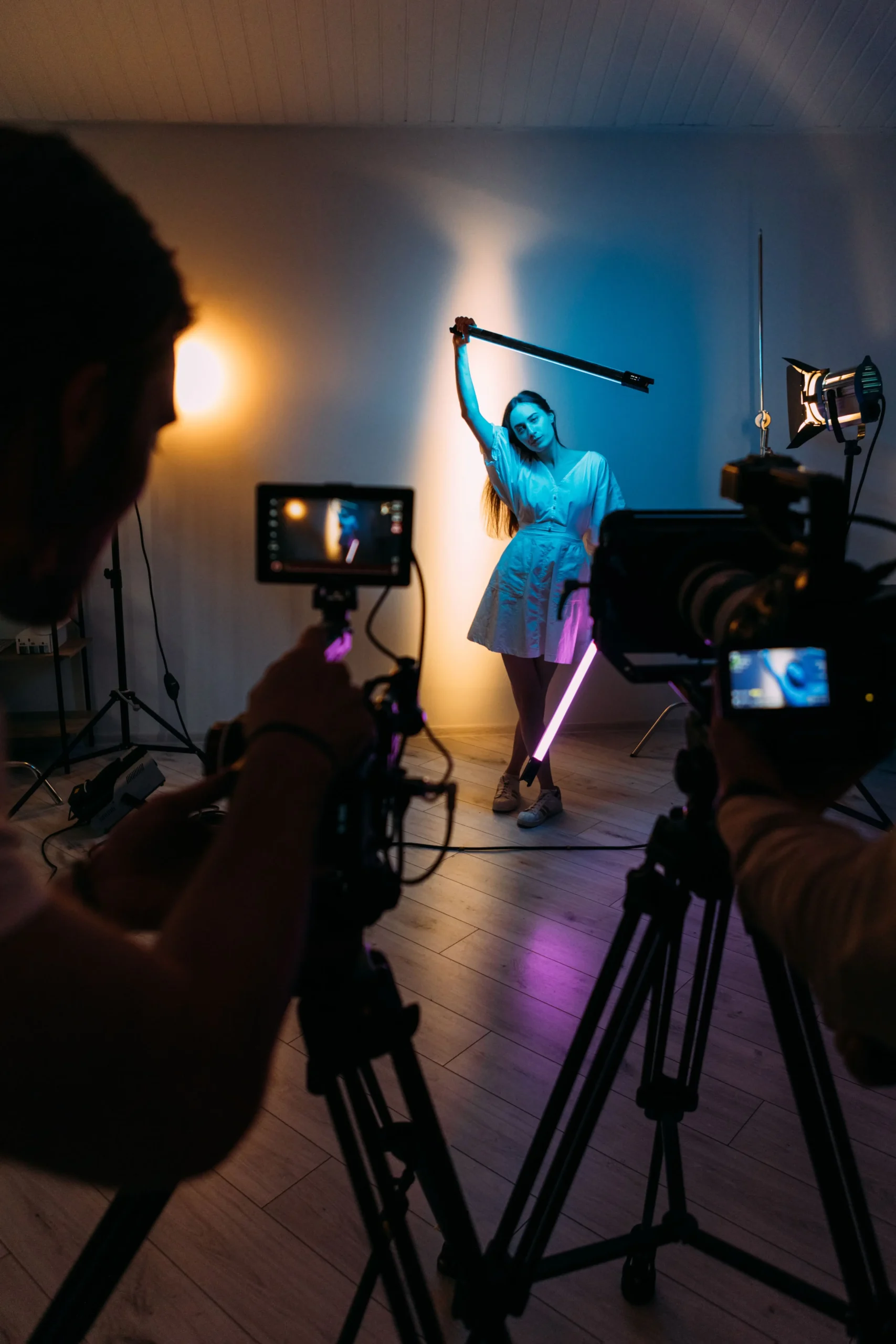 neon-backstage-ultraviolet-studio-two-female-models-move-front-camera-with-bright-colored-led-tubes (1)